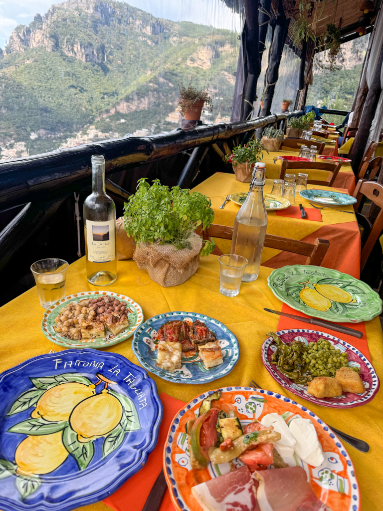 Food at La Tagliata with the Positano coastline in the background