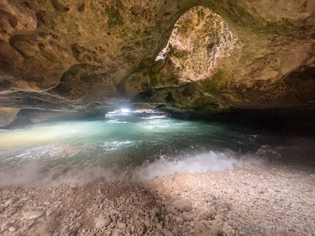 Hidden beach inside Mermaid Caves on Oahu with crystal-clear water