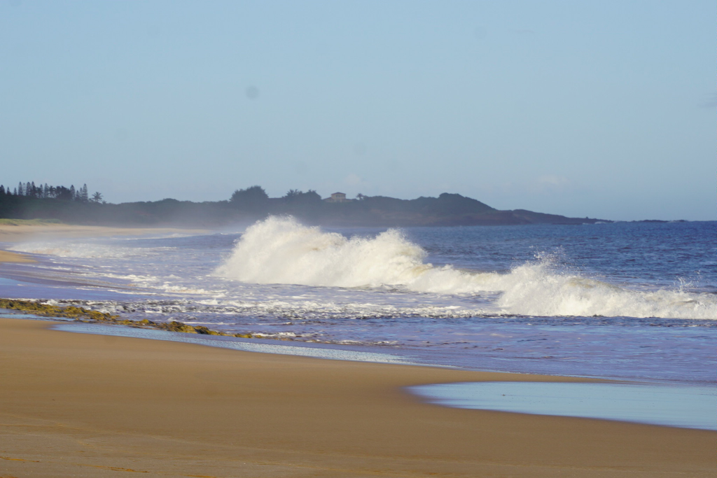 Rough waves crashing onto the golden sand at Papohaku Beach on Molokai, Hawaii.