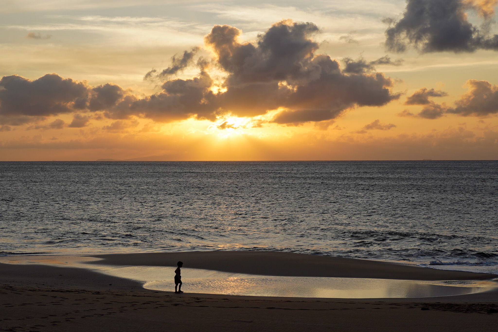 Sunset over the Pacific Ocean at Papohaku Beach on Molokai, Hawaii.